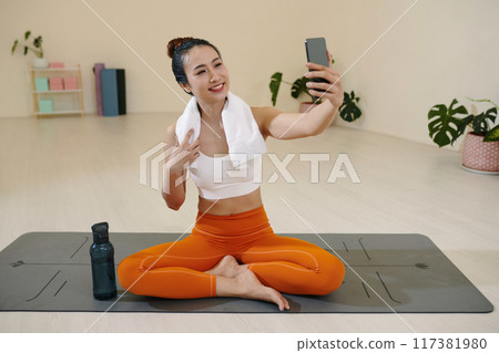 Young Woman Taking Selfie During Yoga Session Without Mat 117381980