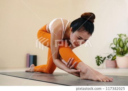 Practicing Yoga with Flexibility and Grace in Studio Setting Practicing Yoga with Flexibility and Grace in Studio Setting 117382025