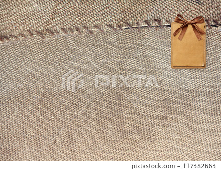 Two pieces of old burlap sewn together with thread. Horizontal background with rustic bag texture 117382663