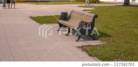 One wooden bench in RETRO style in the recreation area of the city park, summer day One wooden bench in RETRO style in the recreation area of the city park, summer day 117382701