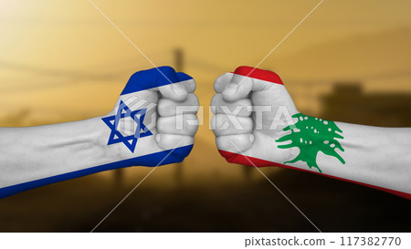Israel against Lebanon, two hands punch each other against a blurred landscape background, fists painted with the national flags 117382770