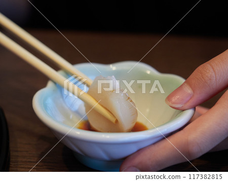 A child eating fresh scallops at a Japanese restaurant in Japan 117382815