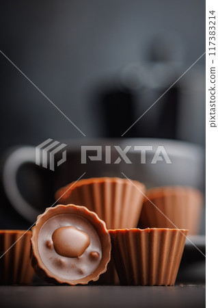 Sweet pralines. Chocolate truffles on black table. Sweet pralines. Chocolate truffles on black table. 117383214
