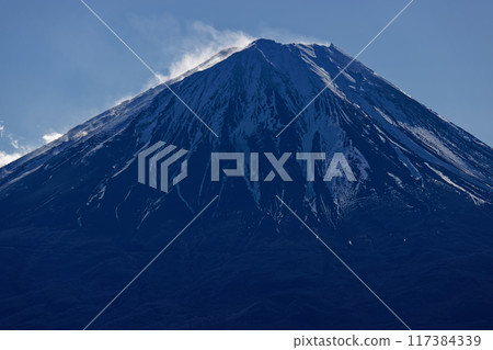 Snow and smoke rising from Mt. Fuji as seen from Onigatake in the Misaka Mountains Snow and smoke rising from Mt. Fuji as seen from Onigatake in the Misaka Mountains 117384339