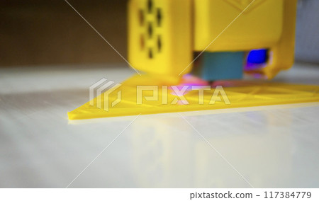 3D printer printing a model. Equipment of a 3D printer during the process of printing a model from molten plastic 3D printer printing a model. Equipment of a 3D printer during the process of printing a model from molten plastic 117384779