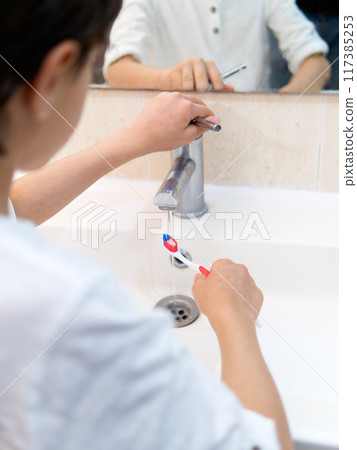 Young boy brushing teeth in bathroom 117385253