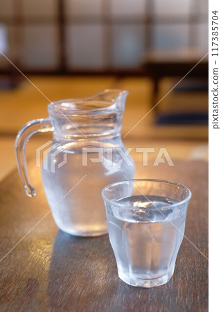 Glass and pitcher of water Glass and pitcher of water 117385704