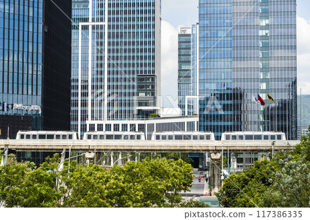 A train on the Wenhu or Brown Line of the Taipei MRT, Taiwan passes by the Nangang with the modern building background. A train on the Wenhu or Brown Line of the Taipei MRT, Taiwan passes by the Nangang with the modern building background. 117386335