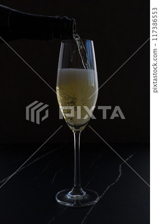 將冷藏好的香檳(起泡酒)倒入長笛杯中 將冷藏好的香檳(起泡酒)倒入長笛杯中 117386553