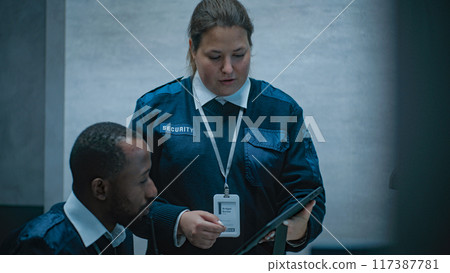 Multiethnic surveillance operators control security cameras in monitoring center Multiethnic surveillance operators control security cameras in monitoring center 117387781