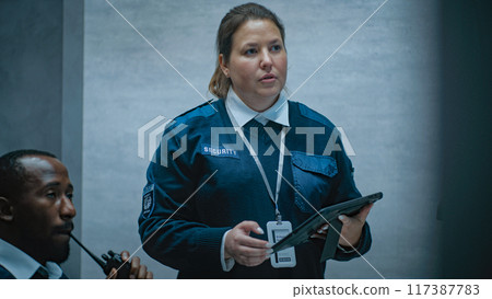 Multiethnic surveillance operators control security cameras in monitoring center Multiethnic surveillance operators control security cameras in monitoring center 117387783