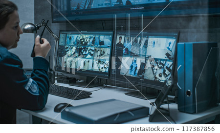 Female dispatch or CCTV operator works on computer in monitoring center 117387856