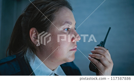 Close up of female security operator or dispatch talking in walkie talkie 117387886