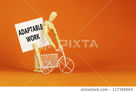 Adaptable work symbol. Concept words Adaptable work on beautiful white paper on wooden clothespin. Beautiful orange background. Bike model. Business Adaptable work concept. Copy space. Adaptable work symbol. Concept words Adaptable work on beautiful white paper on wooden clothespin. Beautiful orange background. Bike model. Business Adaptable work concept. Copy space. 117388664