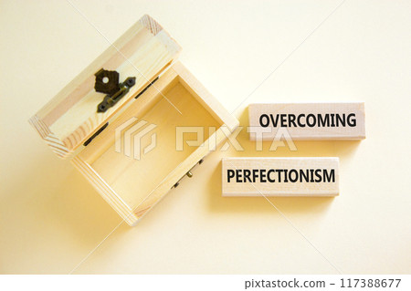 Overcoming perfectionism symbol. Concept words Overcoming perfectionism on beautiful wooden block. Beautiful white background. Empty wooden chest. Business Overcoming perfectionism concept. Copy space 117388677