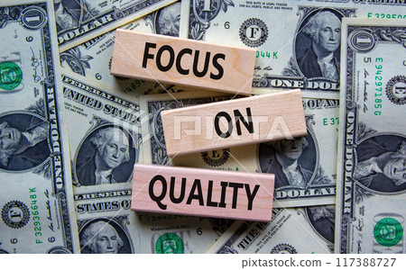 Focus on quality symbol. Concept words Focus on quality on blocks on beautiful background from dollar bills. Business, focus on quality concept. Copy space. 117388727
