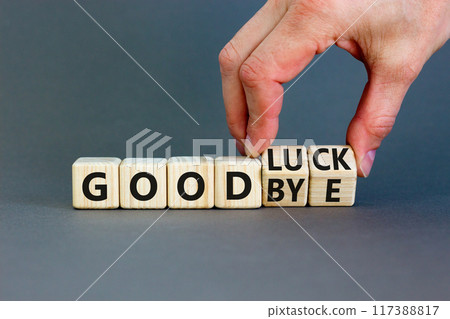 Good luck or goodbye symbol. Concept words Good luck or Goodbye on beautiful wooden blocks. Beautiful grey background. Businessman hand. Business, motivational good luck concept. Copy space. 117388817
