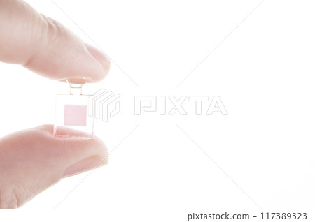 image of miniature glass bottle hand white background 117389323