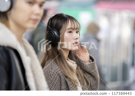 Young woman wearing headphones Young woman wearing headphones 117389443