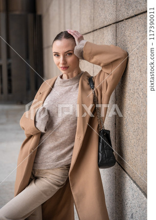 Young beautiful woman wearing coat walking in the city centre of Prague, Europe Young beautiful woman wearing coat walking in the city centre of Prague, Europe 117390011