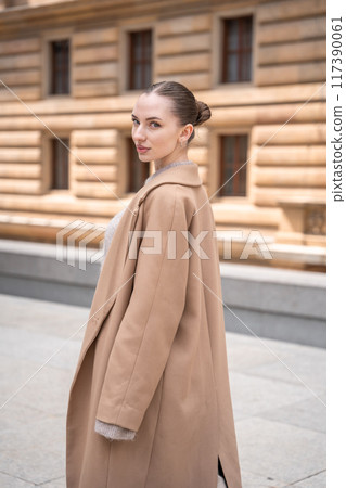 Young beautiful woman wearing coat walking in the city centre of Prague, Europe Young beautiful woman wearing coat walking in the city centre of Prague, Europe 117390061