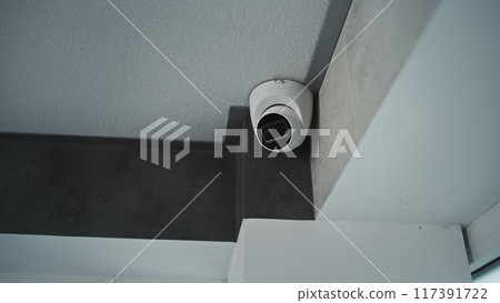 Close up shot of installed CCTV camera hanging on the ceiling Close up shot of installed CCTV camera hanging on the ceiling 117391722