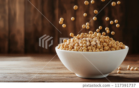 Soy beans falling into white bowl on rustic wooden background with copy space. AI generated 117391737