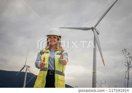 An empowered female engineer working at a wind farm is dedicated to promoting innovation in renewable energy while also emphasizing the importance of sustainability and environmental stewardship 117391954