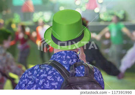 Man wearing a green hat enjoys lively dance event, St. Patrick's Day celebrations 117391990
