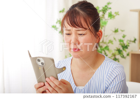 看智能手機有困難的老花眼中年女性 117392167