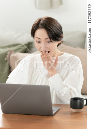 客廳中年婦女電腦驚訝 117392289
