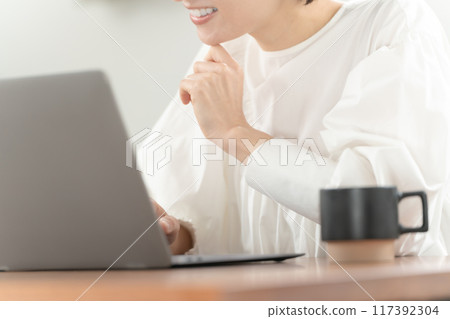Middle-aged woman, computer, smiling, at hand 117392304