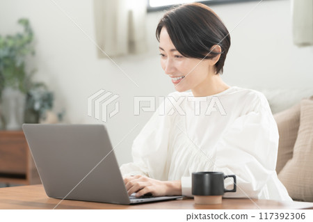 Living room, middle-aged woman, computer operation Living room, middle-aged woman, computer operation 117392306