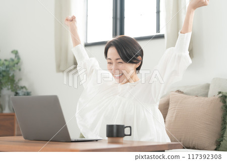 Living room, middle-aged woman, computer, fist pump 117392308