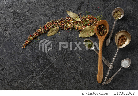 Mix of organic dried spices on a black stone background. 117392368