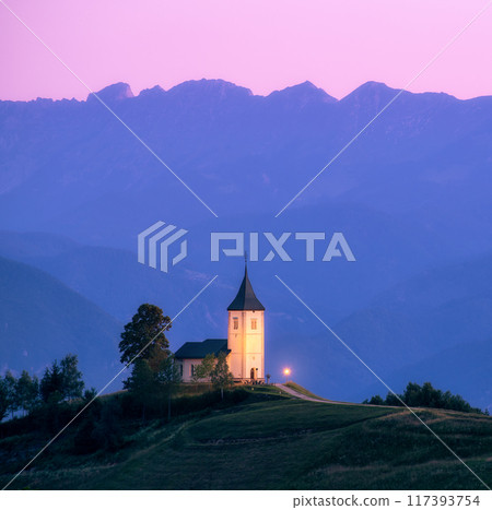 Church on a hill at dusk with mountain ranges in the background 117393754