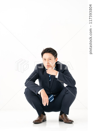 Crouching businessman thinking 117393804