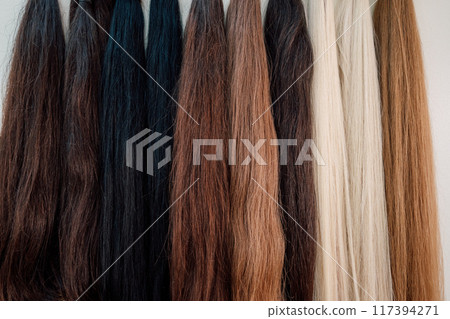 Wig blanks on the wall wig maker. Bundle of natural hair for hair extensions 117394271