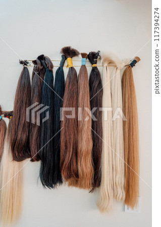 Wig blanks on the wall wig maker. Bundle of natural hair for hair extensions 117394274
