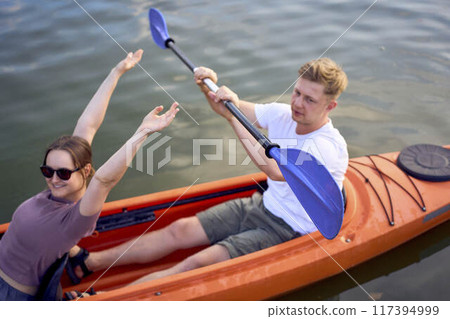 the couple in love kayaking on the river at sunset 117394999