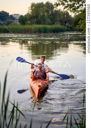 the couple in love kayaking on the river at sunset 117395068