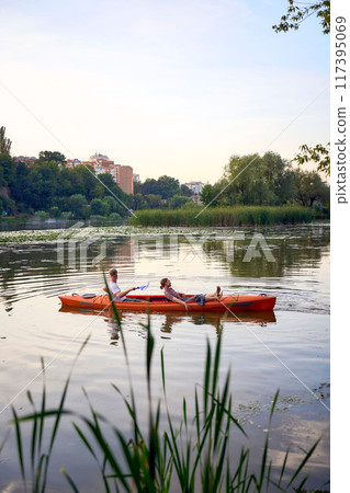 the couple in love kayaking on the river at sunset 117395069