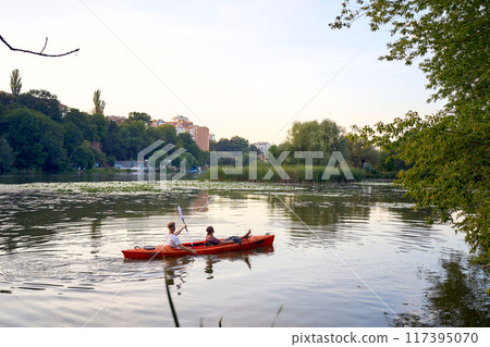 the couple in love kayaking on the river at sunset 117395070