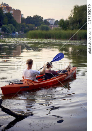 the couple in love kayaking on the river at sunset 117395079