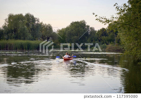 the couple in love kayaking on the river at sunset 117395080