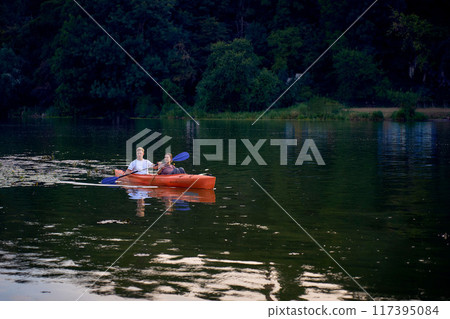 the couple in love kayaking on the river at sunset 117395084