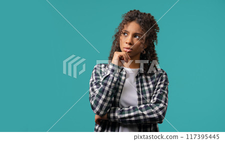 Thinking around african woman, blue background. Puzzled teenager looking answer 117395445