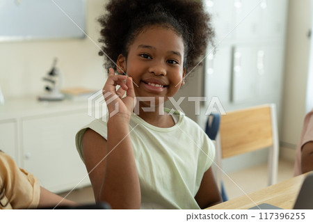 Smiling African American Girl Showing Gesture in Classroom. 117396255