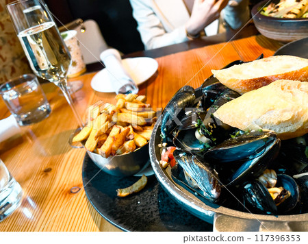 Mussels with lemon and parsley on the wooden plate in restaurant Mussels with lemon and parsley on the wooden plate in restaurant 117396353