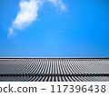 Clouds floating above roof tiles 117396438